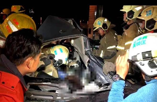 消防人员抢救受困车内的伤者。（洪荣志摄）