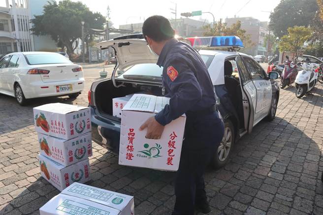 嘉义县朴子警分局辖下15个派出所一早出动警车，载着一箱箱的认捐年菜，送至各辖区内弱势家庭。（张毓翎摄）