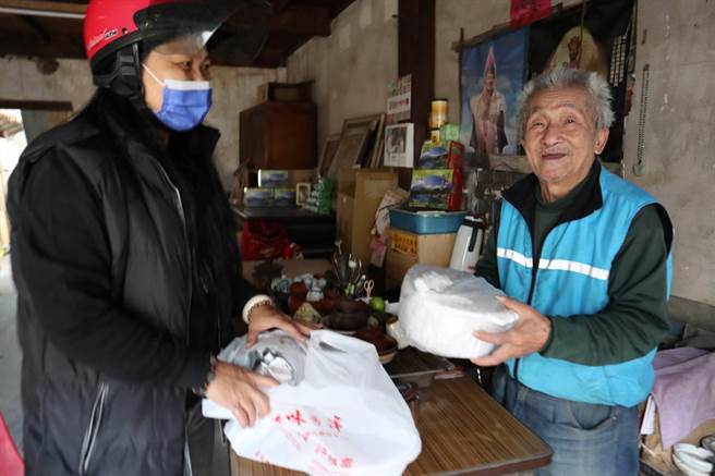 朴子市文化里志工杜佩芬（左）将爱心年菜送到民眾手中。（张毓翎摄）