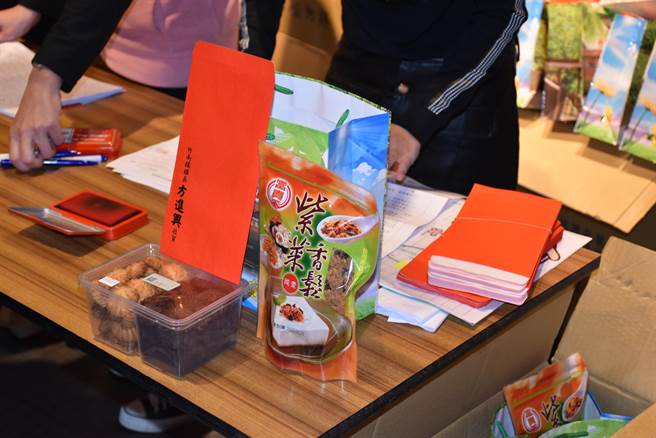 竹南鎮公所及知名肉干業者準備紅包及肉脯等禮品贈送給弱勢住戶。（謝明俊攝）