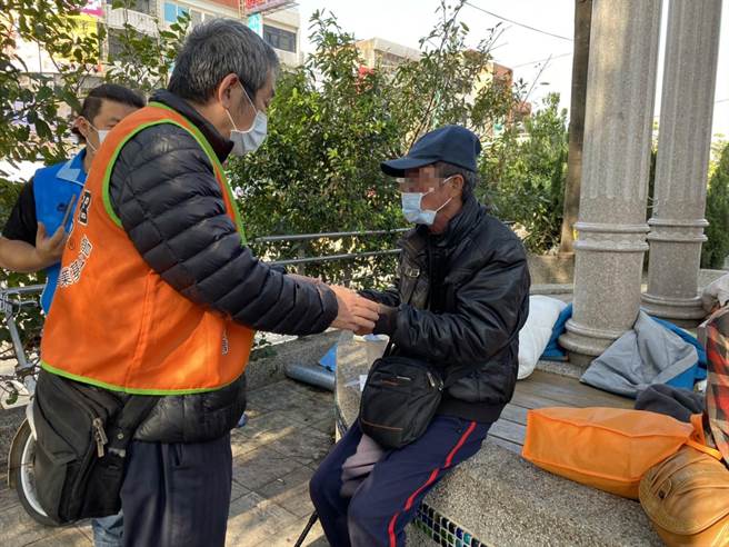 仕招社會福利慈善事業基金會課長周哲仁（左）3日前往新豐火車站，發放小紅包及物資，提供街友度過寒冬。（莊旻靜攝）