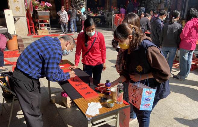 台中市警局雾峰分局春节前「110年加强重要节日安全维护工作」日前邀请中市书法协会干事许金华、庄水南等13位书画家，在福兴宫现场挥毫「写春联、画年画」赠送现场民眾。（黄国峰摄）