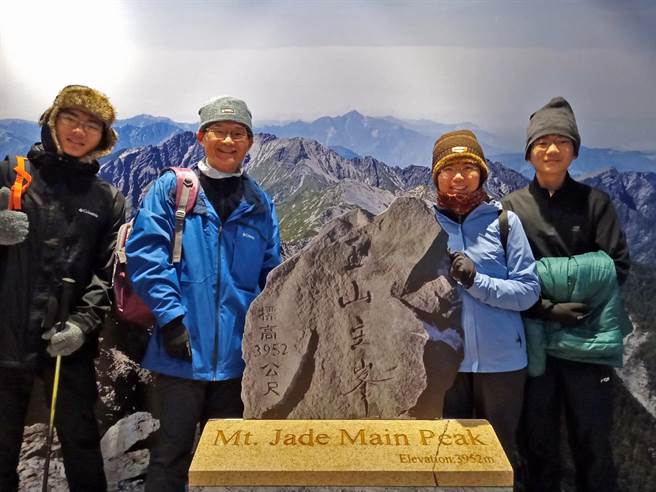 游客在塔塔加与山景相片及「天雷玉石」合影，就像在玉山主峰顶。（玉管处提供／廖志晃南投传真）