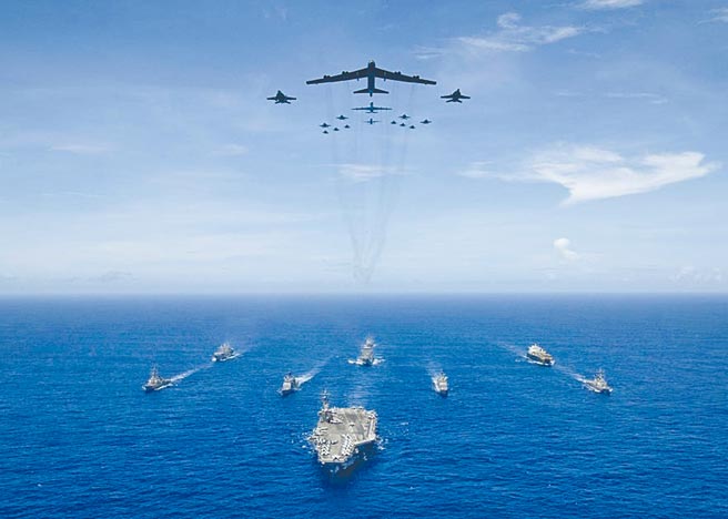 美军在关岛举行「勇敢之盾」演习中，雷根号航母舰队及B-52轰炸机、F/A-18大黄蜂等战机编队前进。（摘自美国海军官网）
