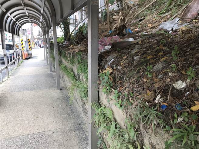 擋土牆傾斜狀況日益嚴重，所幸人行道上的鐵柱支撐住崩盤牆面。（陳彩玲攝）