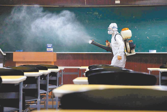 教育部长潘文忠昨宣布，为配合校园全面消毒，高中以下学校寒假将延长4天，改为2月22日开学，图为工作人员在教室进行消毒作业。（本报资料照片）