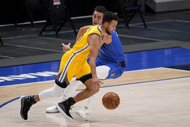 勇士後衛柯瑞運球閃過獨行俠前鋒鮑威爾的防守。(美聯社)