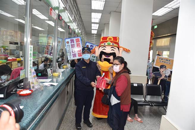 台南市警察局麻豆分局请出财神爷到金融机构发送红包袋、口罩，宣导防抢。（读者提供／刘秀芬台南传真）