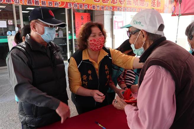 嘉义县义竹乡公所决定依自治条例发放低收家户每人1000元现金，乡长黄阿家（中）5日上午在公所广场前一一发放。（张毓翎摄）