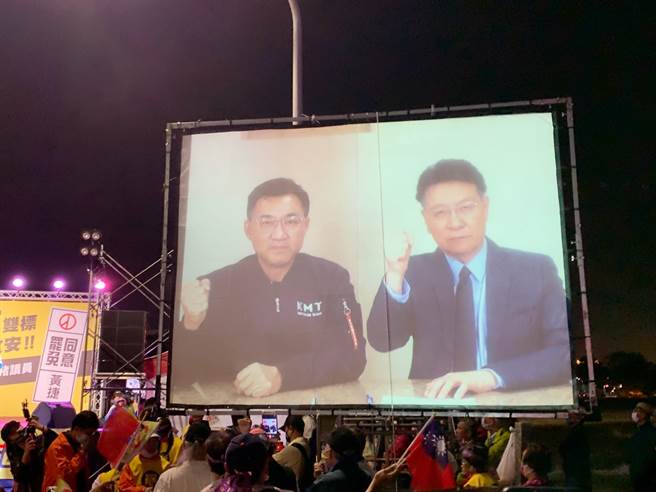 国民党主席江启臣与近日申请入党的媒体人赵少康惊喜同框！两人透过预录影片与民眾致意。（柯宗纬摄）