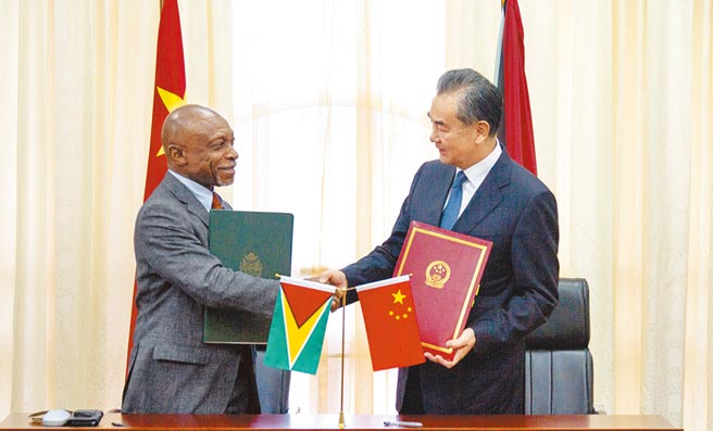 蓋亞那1966年自英獨立後，就與中國大陸建交。圖為2018年時任中國國務委員兼外長王毅（右）與蓋亞那（圭亞那）副總統兼外長格里尼奇簽署經濟技術合作協議。（新華社）