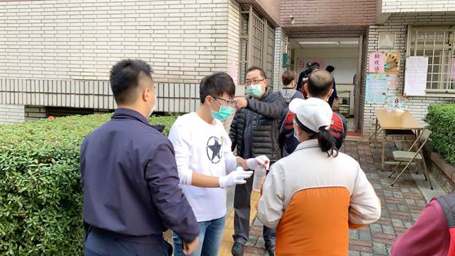 鳳山一處投票所，有中年男子（中）對著媒體及罷捷發言人徐尚賢嗆聲。（柯宗緯攝）