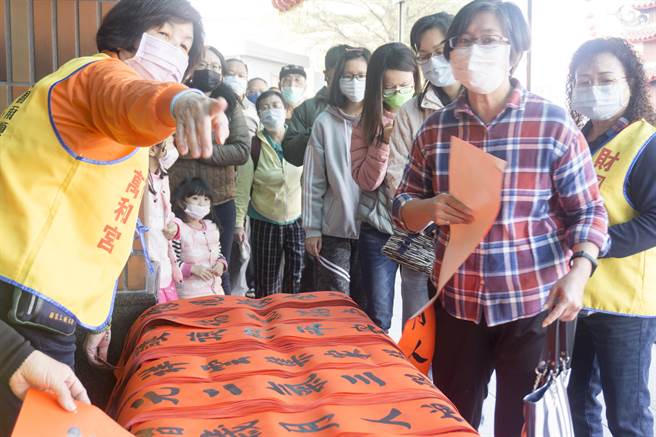 万和宫今天举办送春联活动。因应新冠肺炎疫情升温影响，分送18位书法名家先行写好的春联，不在现场挥毫，吸引乡亲大排成长龙等候领取。（万和宫提供／陈世宗台中传真)