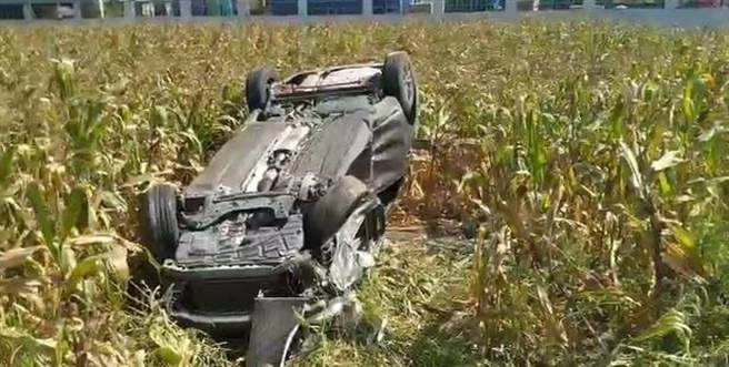 灰色自小客车受撞击后，衝入附近玉米田，车子四轮朝天翻覆。（嘉义县消防局提供／张毓翎嘉义传真）
