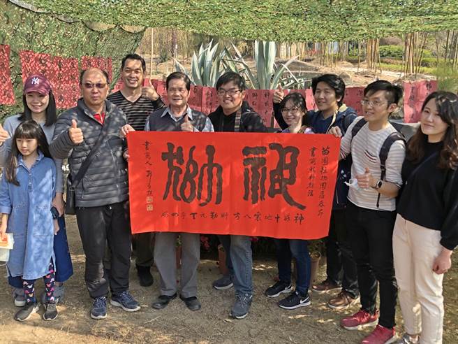 「将军书法家」郑有谅应邀在植物园挥毫，与蜂拥来到的游客开心合影。（李金生摄）