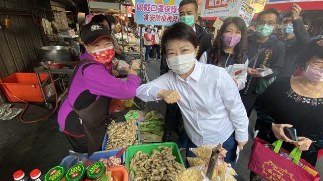 台中市长卢秀燕（右）到市场宣传防疫，摊商及婆妈热情地与她「互碰手肘」打招呼。（陈淑芬摄）