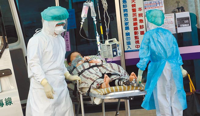 桃园医院新冠肺炎院内感染5日再增1例确诊个案，患者为染疫护理师的家人。在桃园医院急诊室外，医护人员正协助病患转院（示意图，非新闻事件当事人）。（范扬光摄）