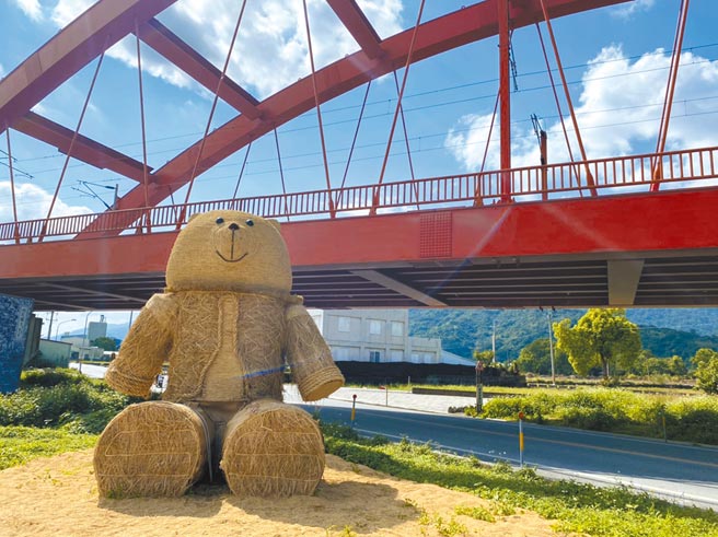 花莲玉溪地区的农友利用收割稻草，在「客城虹桥」下，打造「趴趴熊」稻草艺术，其无辜大眼及蓬松造型，萌度爆表。（罗亦晽摄）
