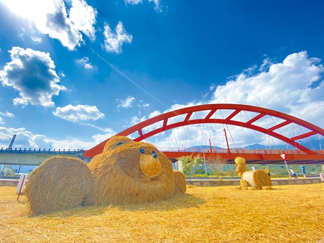 花莲玉溪地区的农友利用收割稻草，在「客城虹桥」下，打造「趴趴熊」稻草艺术，其无辜大眼及蓬松造型，萌度爆表。（罗亦晽摄）