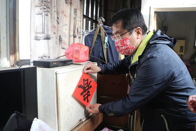黃偉哲幫顏阿公貼上新春聯。（台南市政府提供／曹婷婷台南傳真）