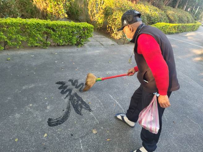 洪宗喜拿扫把地上挥毫成为邻居日常。（照片/游定刚 拍摄）

