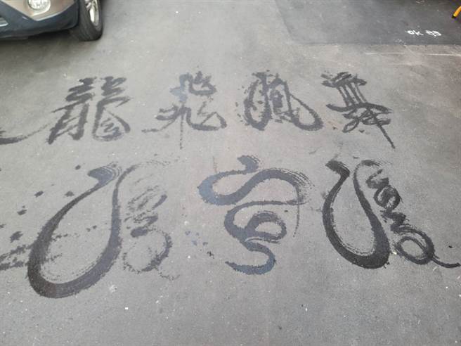 洪宗喜用扫把在地上挥毫，字体犹如书法字。（照片/游定刚 拍摄）