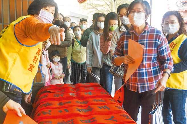 万和宫昨日举办送春联活动，吸引南屯区乡亲大排成长龙等候领取。（万和宫提供／陈世宗台中传真）