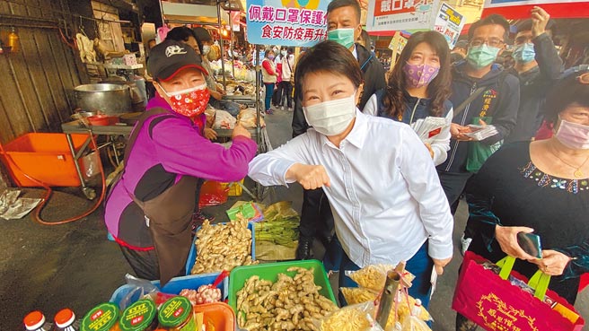 台中市长卢秀燕（中）到市场宣传防疫，摊商及婆妈热情地与她「互碰手肘」打招呼。（陈淑芬摄）