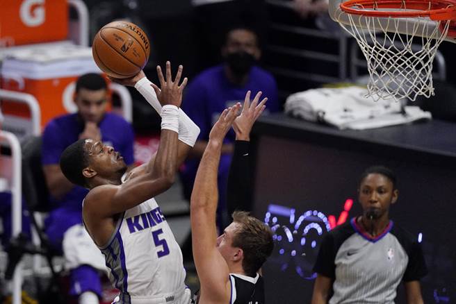 无视快艇后卫肯纳德的防守，国王后卫福克斯强势切入上篮。(美联社)