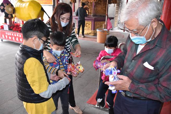 保民宫并准备立体纸雕牛灯笼送给小朋友玩。（谢明俊摄）