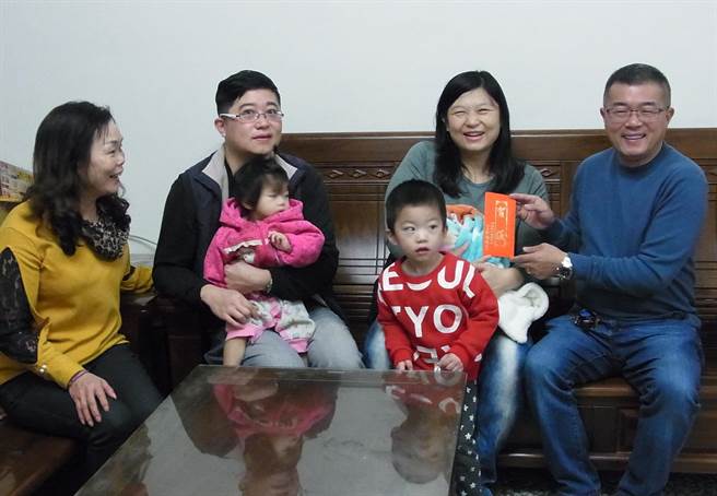 云林县四湖乡年出生人口跌破百人，乡长苏国珑（右）发送新生儿补助金鼓励生育。（张朝欣摄）