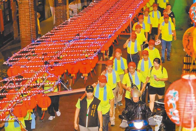 水灯节有3大座20公尺高水灯排，需要数十位民眾用肩扛着游街，场面盛大。（本报资料照片）