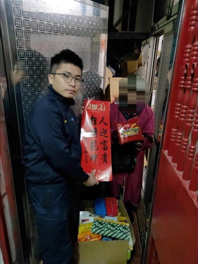 内湖派出所长汪昕儒代表致赠老妇生活物资及市府春联等。(翻摄照片／林郁平台北传真)