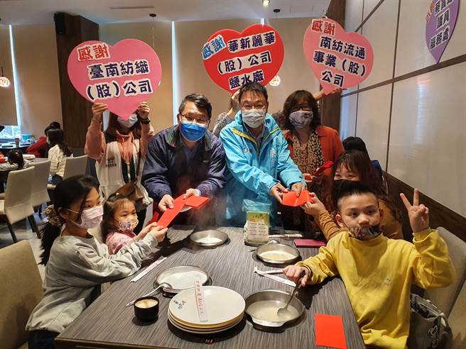 台南市议员蔡育辉(后右二)连续第3年号召地方企业，请家扶亲子百人一同享用火锅，还加送红包、年菜。(家扶基金会提供／刘秀芬台南传真)