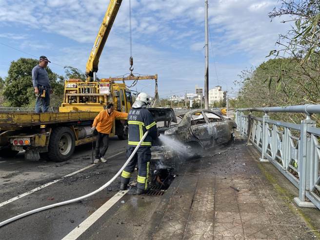 頭份市頭份大橋9日發生轎車自撞燈桿起火燃燒事故，消防人員獲報趕抵迅速撲滅火勢。（消防局提供／何冠嫻苗栗傳真）
