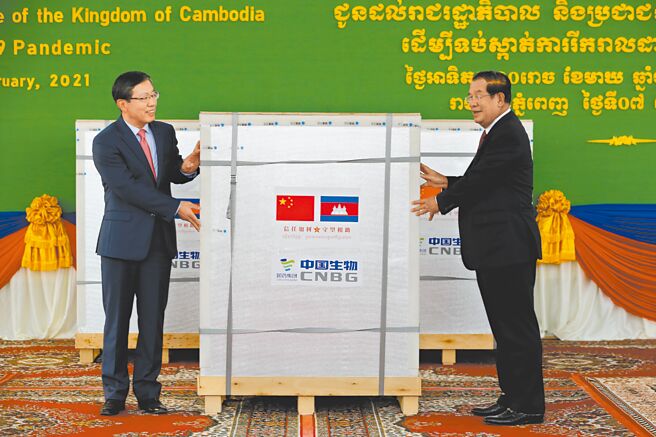 中国驻柬埔寨大使王文天（左）7日在柬埔寨金边国际机场，向柬埔寨首相洪森（右）正式移交中国援柬新冠疫苗。（新华社）