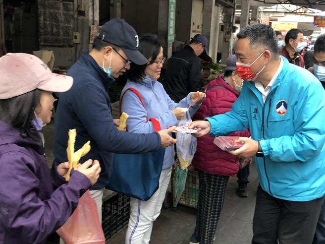 杨镇浯县长向摊商及採买民眾拜年，发送春联及寓意「十全十美」的10元小红包。（李金生摄）