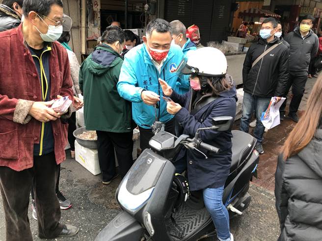 杨镇浯县长向摊商及採买民眾拜年，发送春联及寓意「十全十美」的10元小红包。（李金生摄）