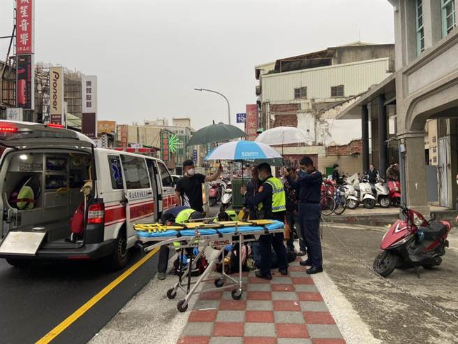 女子發生車禍倒地又碰上雨天，警察替女子打傘遮雨直到消防隊員抵達。（民眾提供／邱立雅竹市傳真）