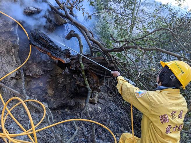 女性森林護管員巾幗不讓鬚眉，無畏崎嶇地勢，忍受濃煙，拉設水線進行殘火整理。（東勢林管處提供／王文吉台中傳真）