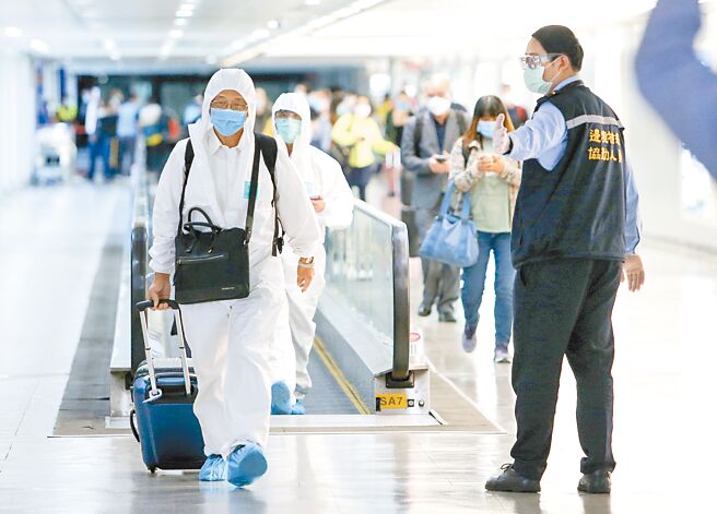 中央流行疫情指挥中心10日公布国内新增2例境外移入案例，分别自缅甸及印尼入境。图为在桃园机场入境长廊里，旅客正由疾管局协勤人员检查入境健康声明书等资料。（陈麒全摄）