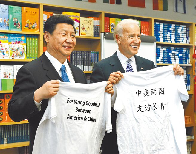 中國農曆除夕（11日），美國總統拜登和大陸國家主席習近平首度通話。圖為2012年2月17日，時任大陸國家副主席習近平（左）和時任美國副總統拜登（右）一同參觀洛杉磯的國際研究學習中心，兩人互換學生贈送印有「中美兩國 友誼長青」字樣的T恤。（新華社）