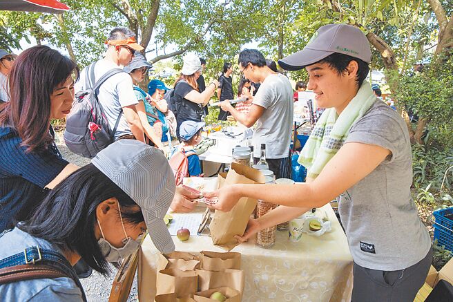 舉辦市集是深溝小農銷售的重要通路，來自美國的蔡雪青（右）在市集販賣自種的農產品。