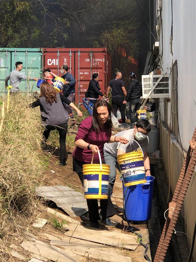 由於現場距離加油站不到100公尺，且附近店家、住宅密集，住戶在火起時即用水桶排隊灌救。（李金生攝）