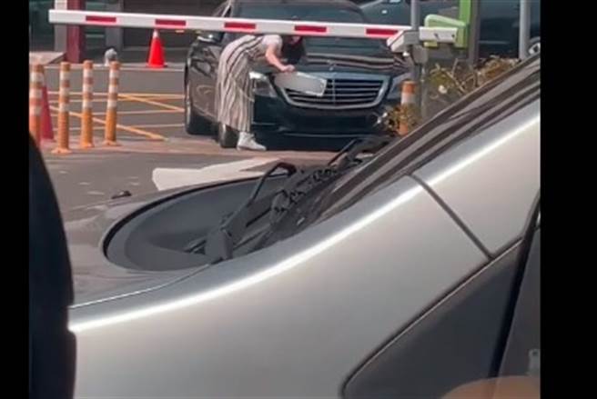 一辆宾士被挡在入口无法进场，一名女子霸气下车拆车牌，朝着感应系统乱挥，让网友全看傻。（图／翻摄自爆废1公社）
