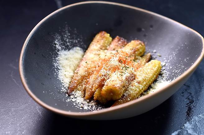 麻药玉米笋〉是将玉米笋涂了奶油、美奶滋烤熟，再洒了帕玛森起司粉和细辣粉，口感与风味迷人，一支接一支停不下。（图／姚舜—