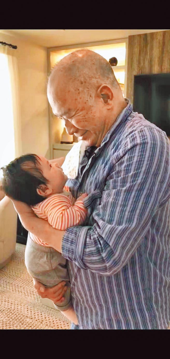 首度当爷爷的吴宇森，深情款款抱着孙女吴慧兰。（倪有纯提供）