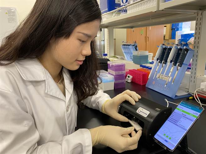 清华大学研究团队把快筛试片放进可携式轻型判读机，就可以用手机读出抗体浓度数值，了解保护力的强弱。（清华大学提供／陈育贤新竹传真）