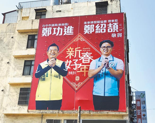 市议员郑功进与儿子郑绍颉合照的新春祝贺看板，告知选民待时机成熟，他就交棒。（郑功进服务处提供／陈世宗台中传真）