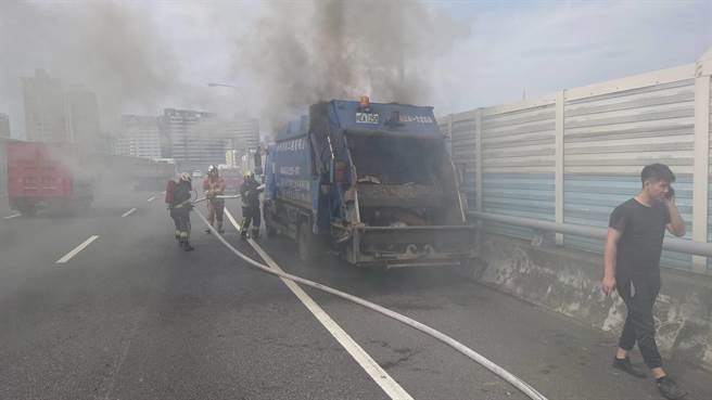 一辆民间垃圾车今（19日）上午11时许，行经国道3号北上29公里处、靠近新店隧道口突然起火燃烧，浓烟不断从垃圾车车斗内窜出。（叶书宏翻摄）